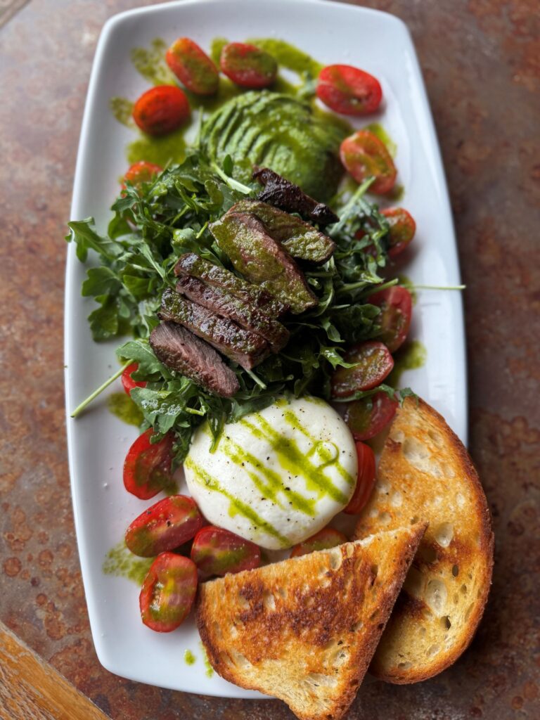Enjoy a great meal like this Steak and Burrata Salad in the Pub Bar & Grill at Park Place Lodge, Fernie BC